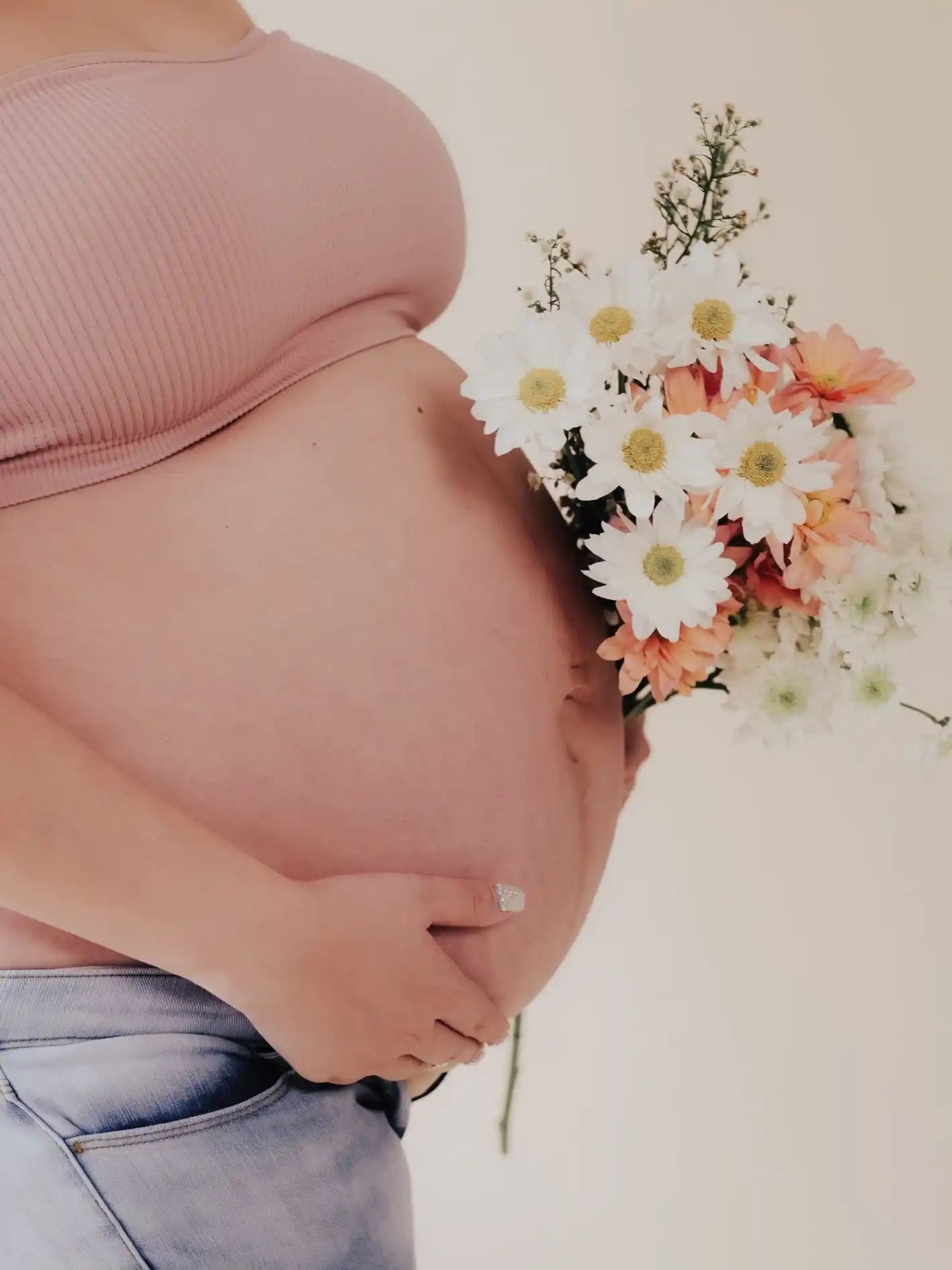 Vientre de embarazada decorado con flores en un blessing way
